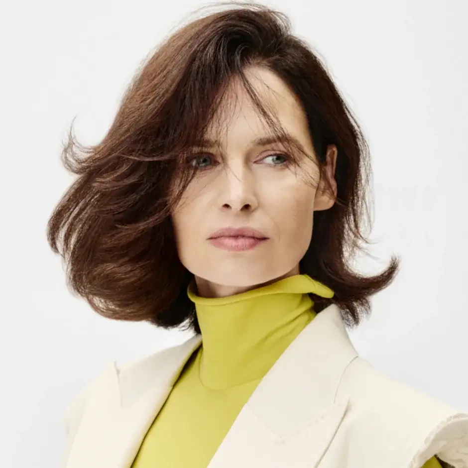 Frau mit braunem Naturhaar und voluminösem Haarstyling