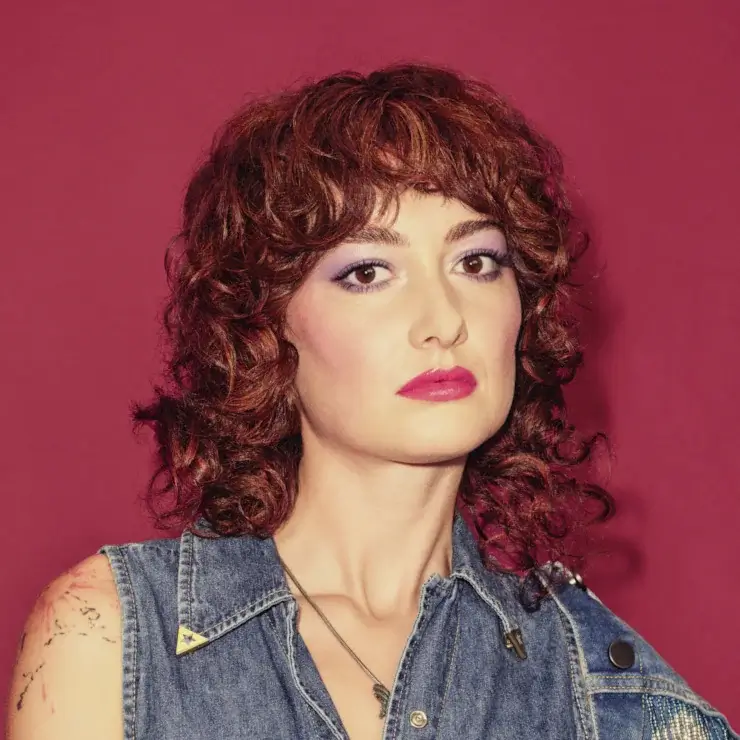 Frau mit kurzem rotem Lockenhaar und modernem Haarlook