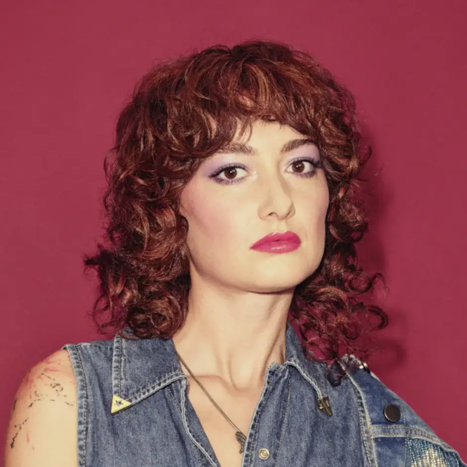 Frau mit kurzem rotem Lockenhaar und modernem Haarlook